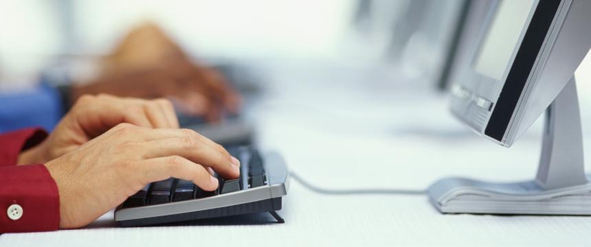 Hands typing on keyboard of computer
